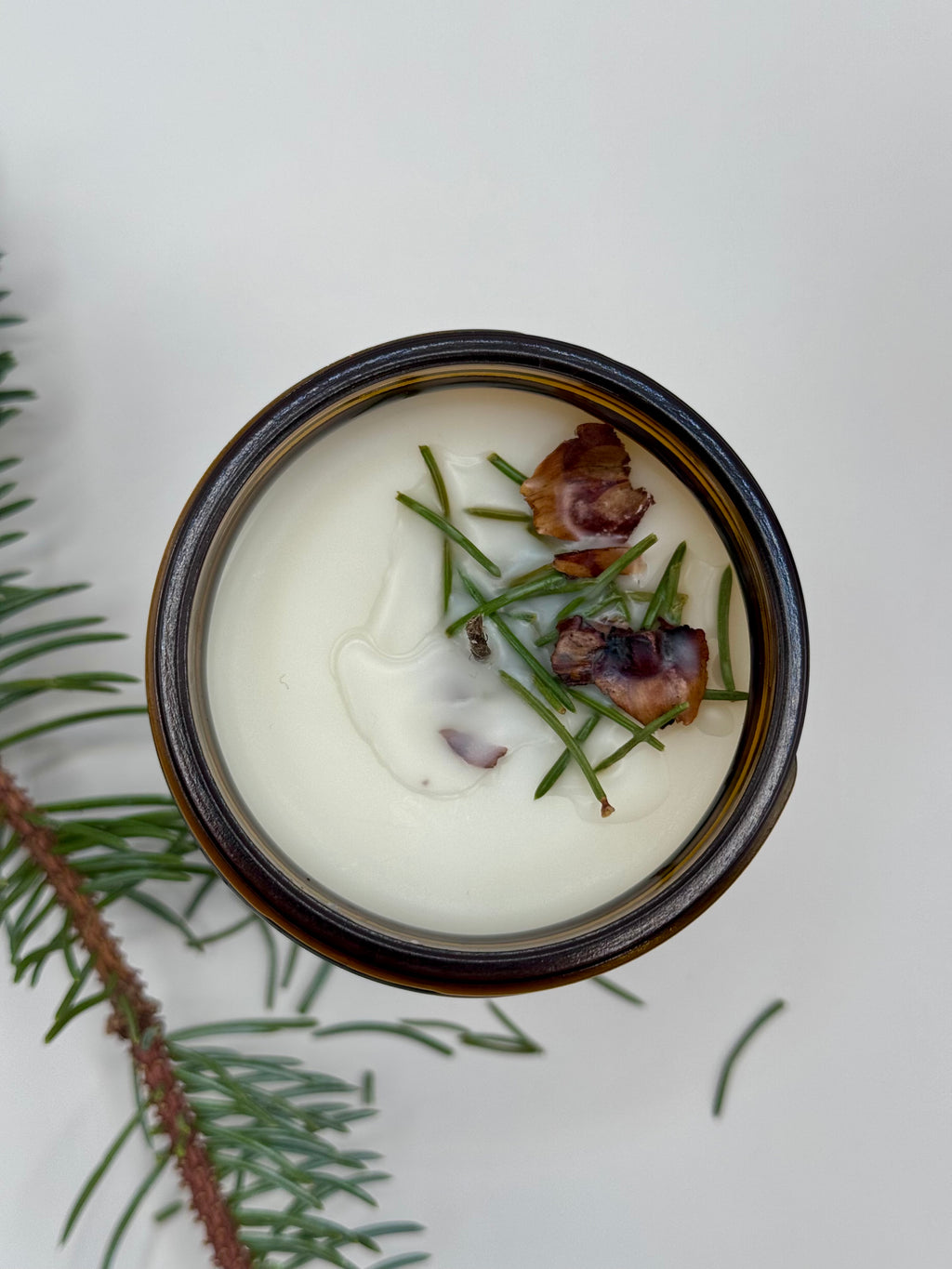 Jar of cream with greenery on a light background